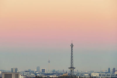Modern buildings in city against sky during sunset