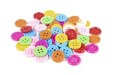 High angle view of multi colored buttons on white background