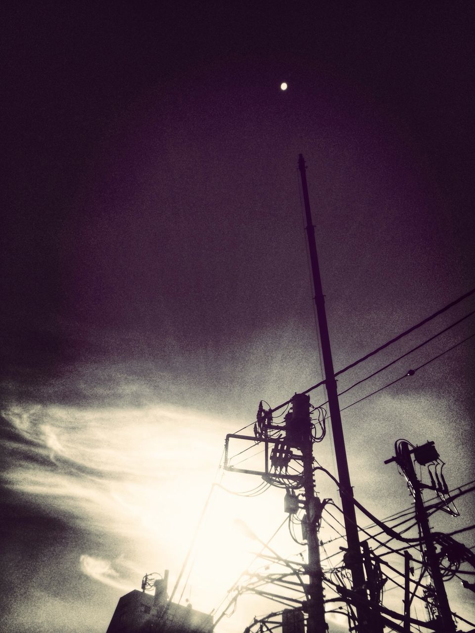 low angle view, silhouette, sky, street light, lighting equipment, cloud - sky, power line, electricity, dusk, built structure, sun, electricity pylon, technology, outdoors, cable, sunset, connection, cloudy, cloud, nature