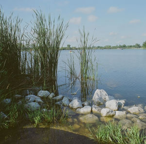 Scenic view of lake against cloudy sky