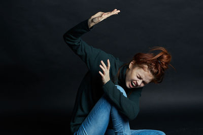 Full length of woman wearing hat against black background