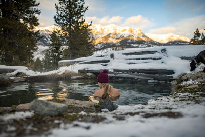 A woman enjoying an evening sunset in a hot spring.