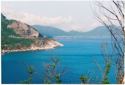 Scenic view of sea and mountains against sky