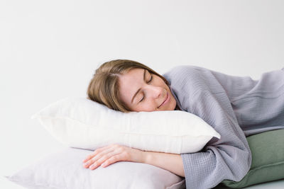 Portrait of young woman lying on bed at home