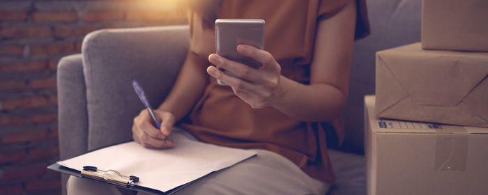 Midsection of woman using mobile phone