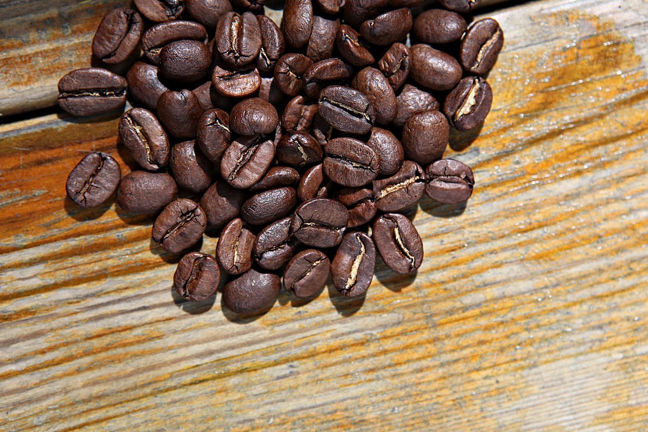 HIGH ANGLE VIEW OF COFFEE BEANS ON WOODEN TABLE