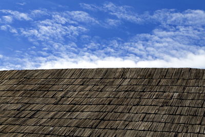 Low angle view of roof against cloudy sky