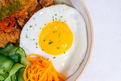 A portion of breakfast with sunny side-up eggs photographed at close range from above.