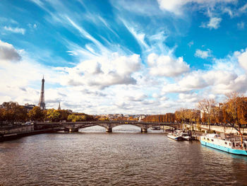 Bridge over river against cloudy sky