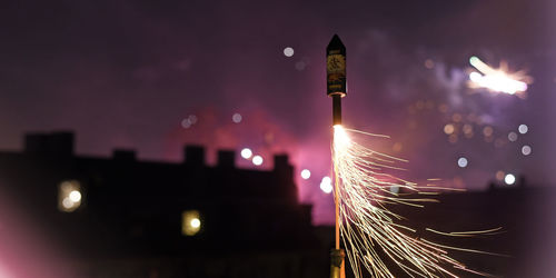 Low angle view of illuminated lighting equipment at night