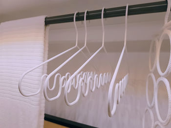White curvy cloth hangers and towel inside the wardrobe