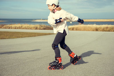 Full length of girl roller skating outdoors