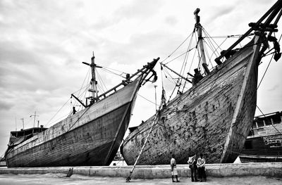 Low angle view of boats moored at harbor against sky