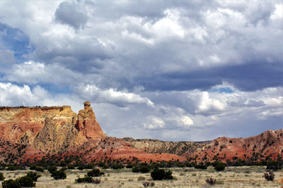 Rock formations on landscape against cloudy sky