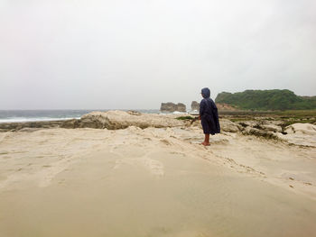 Rear view of people walking on beach