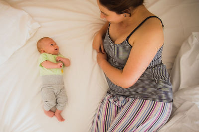 Midsection of woman lying on bed