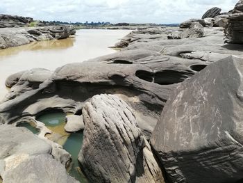 Rocks on beach against sky