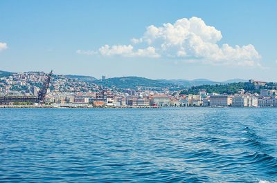 Scenic view of sea by town against sky