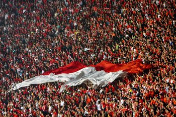 Spectator with indonesian flag at soccer stadium