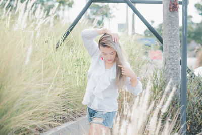 Woman standing amidst grass