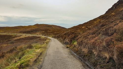 Empty road along countryside landscape