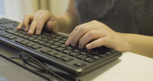 Midsection of woman typing on keyboard