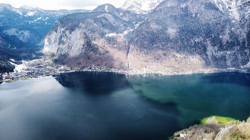Scenic view of lake by mountains against sky