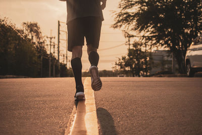 Low section of man running on road