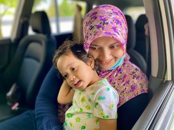 Portrait of a smiling girl sitting in car