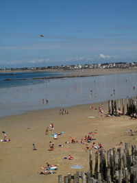 People on beach by sea against sky