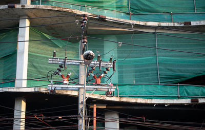 Low angle view of electricity pylon in city