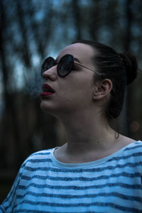 Close-up portrait of a young woman wearing sunglasses