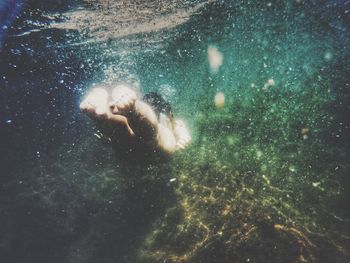 Close-up of woman swimming underwater
