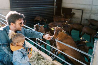 Side view of boy with goat