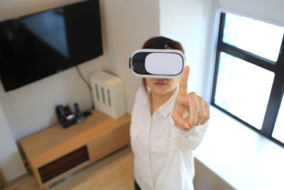 Woman using virtual reality simulator at home