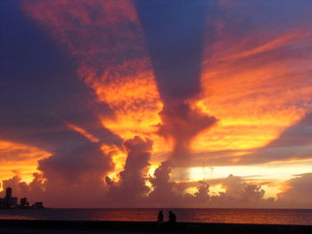 Scenic view of sea against dramatic sky during sunset