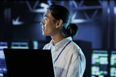 Side view of man using laptop at office