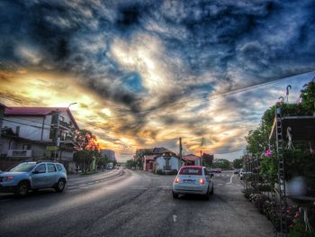 Cars on road against cloudy sky