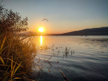 Scenic view of lake against sky during sunset