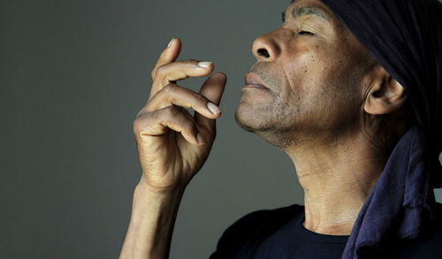 Side view of man looking away against black background