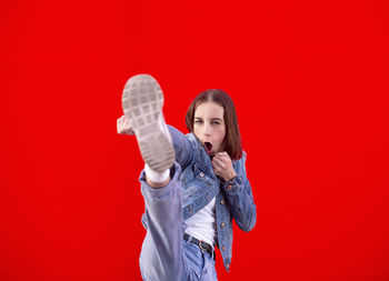 Portrait of a teenage girl against red background