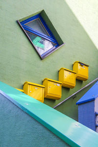 Low angle view of mailboxes on wall by staircase
