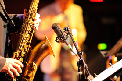 Midsection of man playing saxophone at music concert