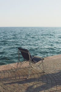 Deck chairs on beach against clear sky