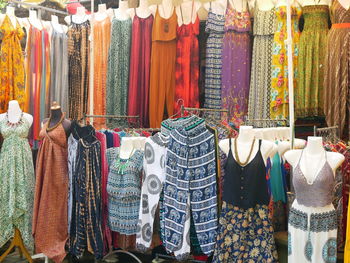 Various clothes hanging in store for sale at market stall