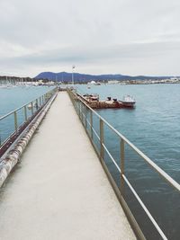 View of pier on sea against cloudy sky