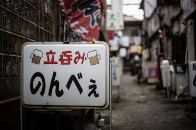 Close-up of information sign on street in city