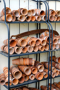 Flower pots. random piles and stacks of vintage terracotta flowerpots on metal shelf