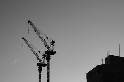 Low angle view of crane against clear sky