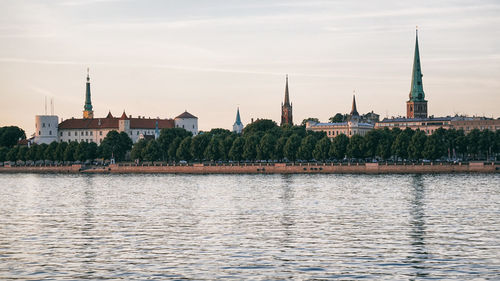 River by buildings against sky in city